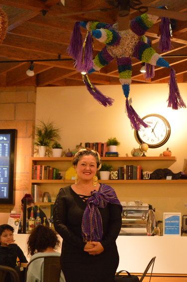 Maribel Arredondo standing underneath her favorite piñata in Smoky Hill Library on Sept. 14.